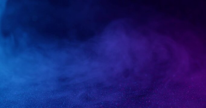 Vapor art. Shimmer texture. Defocused blue purple neon colorful ink in water haze flow fume flying on abstract dark black background.