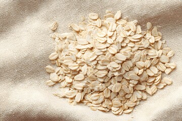Rolled oats on a beige fabric background 