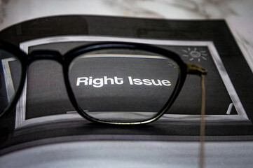 Eyeglasses resting on a printed page with the bold words Right Issue in focus, offering a...