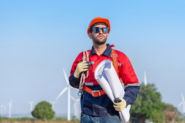 Male man engineer inspection posing check control wind power machine in out door wind energy factory. Young man technician professional worker check wind power machine for maintenance turbine