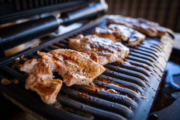 Pork steak being grilled on an electric grill, close-up