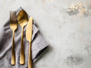 Elegant Gold Cutlery with Gray Napkin on Textured Background