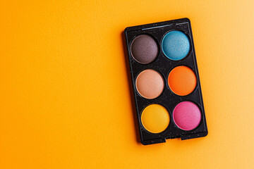 Vibrant Makeup Palette with Colorful Eyeshadow on Bright Orange Background