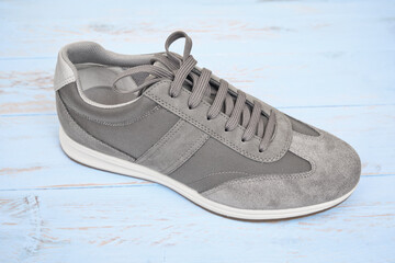 A studio shot of sneaker sport shoe on wooden blue background        