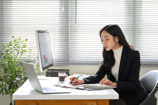 Focused businesswoman working with documents and a computer in a modern office