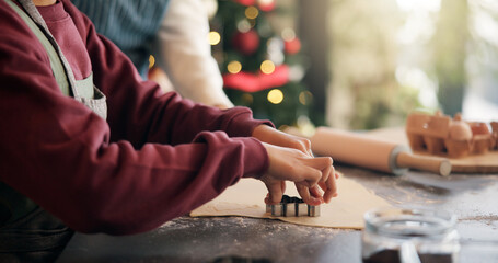 Christmas, cookie cutter and hands of child with parent in kitchen of home for festive tradition. Baking, help and holidays with family at apartment together for cooking or learning in December