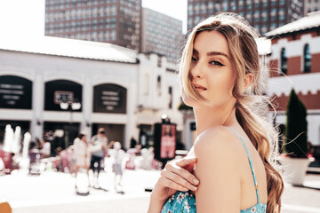 Young beautiful smiling hipster woman in trendy summer dress clothes. Sexy carefree model posing on...