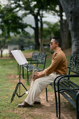 Peaceful moment of a man relaxing with his trumpet on a park bench
