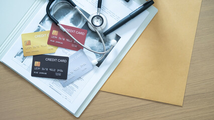 Variety of credit cards on hospital documents and stethoscope, highlighting healthcare payments.