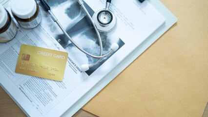 Golden credit card on medical documents with stethoscope and medicine bottles, representing health expenses and financial planning.