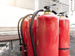 Red fire extinguisher with outdoor background for the concept of controlling small fires.