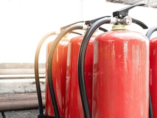 Red fire extinguisher with outdoor background for the concept of controlling small fires.