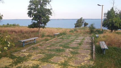 Old park by the river, an alley with benches and water visible