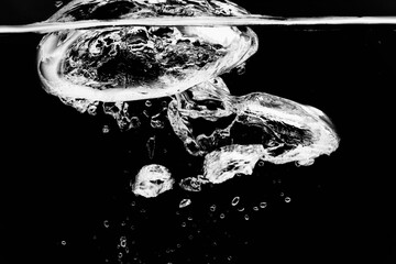黒の背景に水面に浮上する気泡.