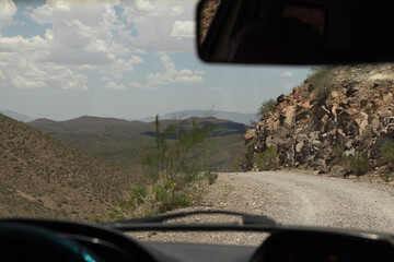 Driving down a winding gravel road in the desert mountains