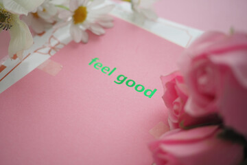 Bright pink card with feel good message and flowers nearby