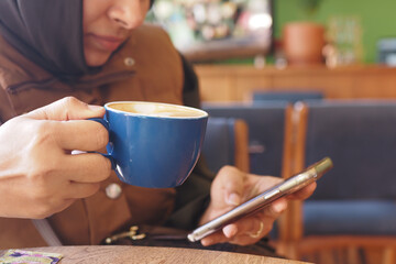 Enjoying coffee while checking messages at a cozy cafe