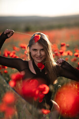 Poppy girl field: Woman holds poppies playfully in vast field at daytime for enjoyment/beauty.