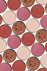 Eyeshadow palette, mix of shimmer shades in pink, red, brown, purple hues. Minimal top view pattern...
