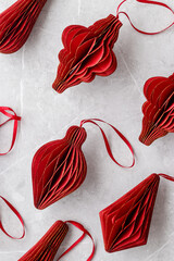 Red Christmas paper baubles as shape Lantern on marble grey table, Scandinavian Christmas honeycomb...