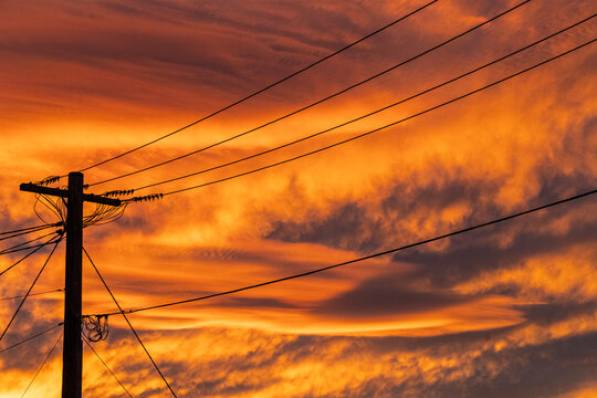 Electricity pole and wires with red sky sunset