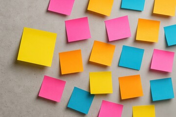 Scattered sticky notes of vivid colors on gray concrete background symbolizing brainstorming multitasking and fast idea capture