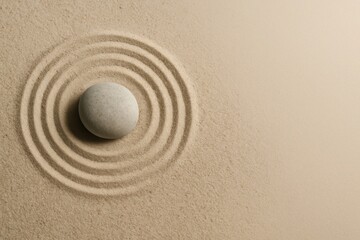 Single stone in the center of concentric circles on sand — concept of focus, precision, and goal orientation