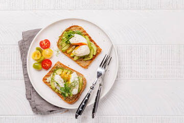 Delicious avocado toasts topped with perfectly cooked poached eggs