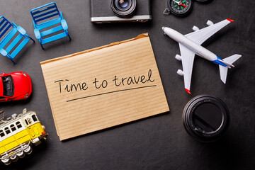 Creative flat lay of a travel-themed desk with notepad for plans