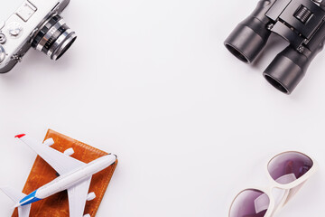 Travel-themed flat lay with toy airplane, camera, and sunglasses
