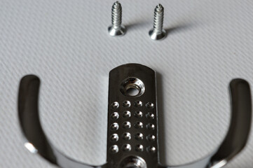 metal wall hook with screws on white background, useful for concepts like home organization, DIY...