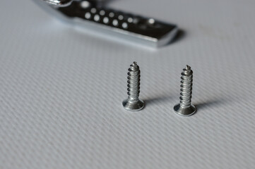 metal wall hook with screws on white background, useful for concepts like home organization, DIY...