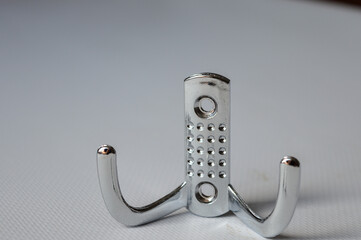 set of three metal wall hooks aligned on white background, ideal for concepts of home storage,...