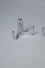 set of three metal wall hooks aligned on white background, ideal for concepts of home storage,...