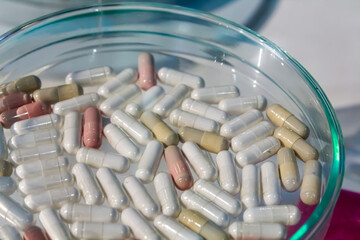 Newly developed pharmaceutical capsules rest on a sterile surface after laboratory testing,...