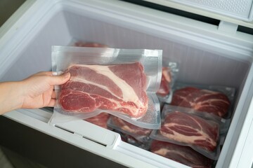 hand put raw meat vacuum bag in freezer for storage