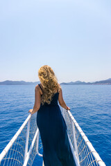 Fototapeta premium Tekirova, Turkey - June 14, 2025: woman stands on the bow of a yacht and looks into the distance
