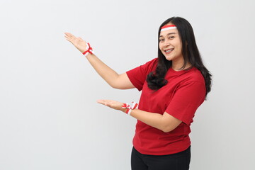 Happy Indonesian woman with red and white ribbon celebrating Indonesian independence day while...