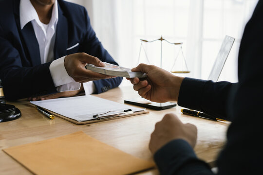Lawyer giving advice and handing over cash during a legal meeting, symbolizing financial transactions, possible bribery, or settlement in a professional environment where elements of law and justice a