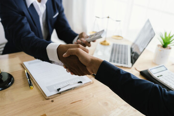 Close-up of lawyer giving legal advice showing professional handshake which is a symbol of...