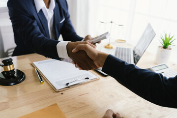 Close-up of lawyer giving legal advice showing professional handshake which is a symbol of...