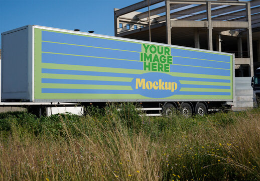 Mockup Design for Empty Trailer positioned near an industrial area under a clear blue sky.