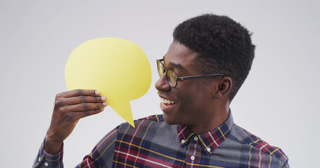 Happy, black man and social media with speech bubble in studio for chat on white background. Male...