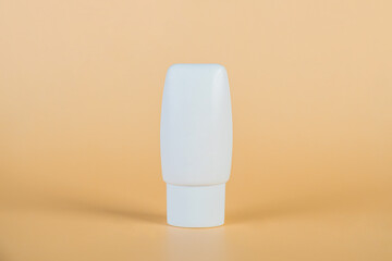 Plastic white tube for cream or lotion. Skin care or sunscreen cosmetic with stylish props on cream...