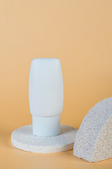 Plastic white tube for cream or lotion. Skin care or sunscreen cosmetic with stylish props on cream background.