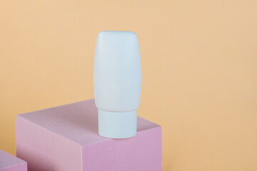 Plastic white tube for cream or lotion. Skin care or sunscreen cosmetic with stylish props on cream...