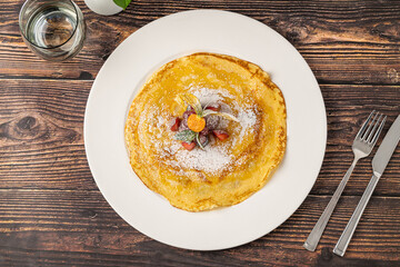 Thin crepe topped with powdered sugar and fresh mixed berries