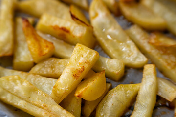 Homemade golden potato wedges baked in the oven, close-up