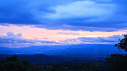 Obraz premium Serene twilight landscape showcasing a breathtaking panorama of layered mountains under a vibrant, colorful sky