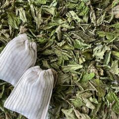 Dried mint leaves for herbal tea with linen sachet bags on white background, natural organic...